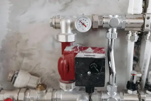 მთავარი Close-up view of an industrial plumbing system featuring a pressure gauge and steel pipes.